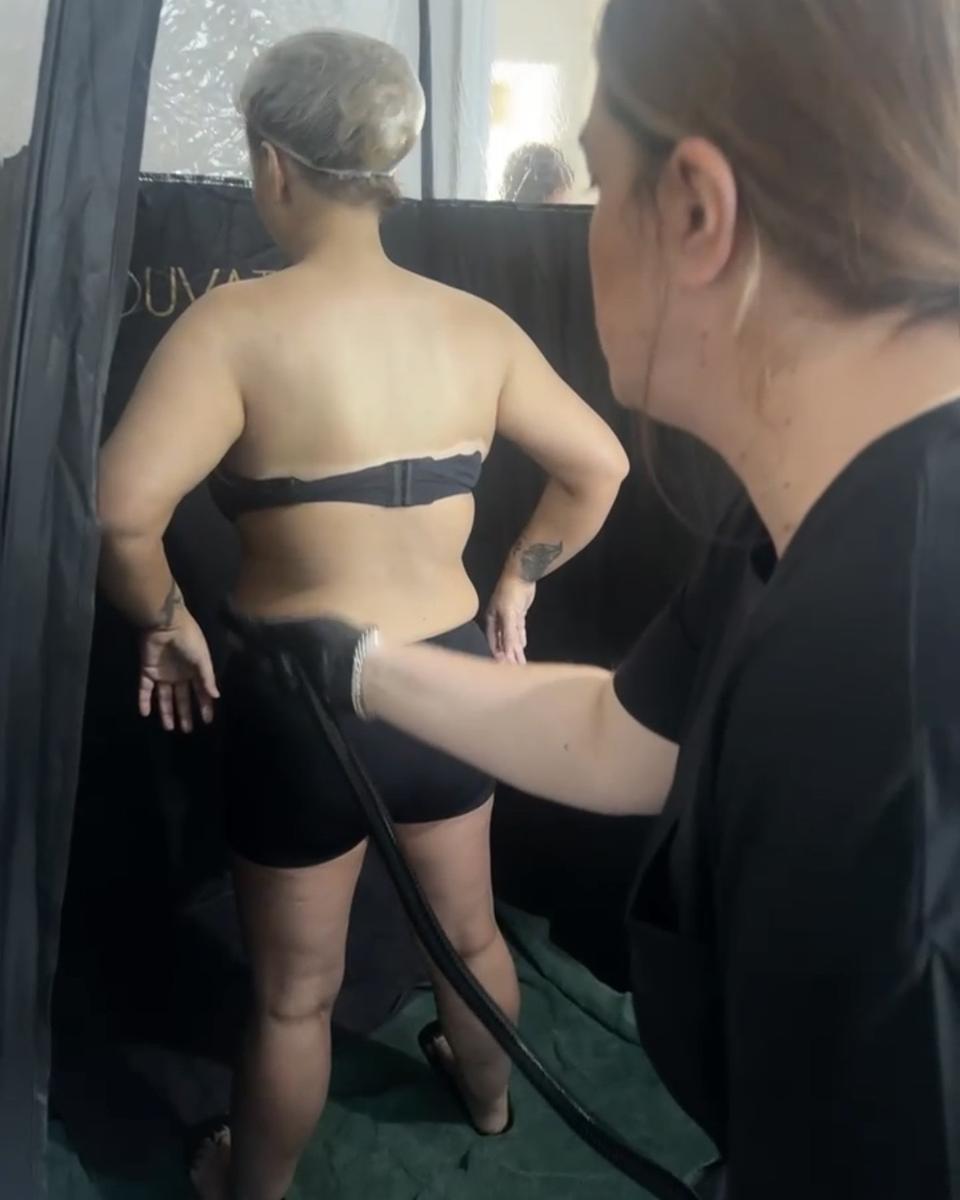 Siddy spray tanning a client